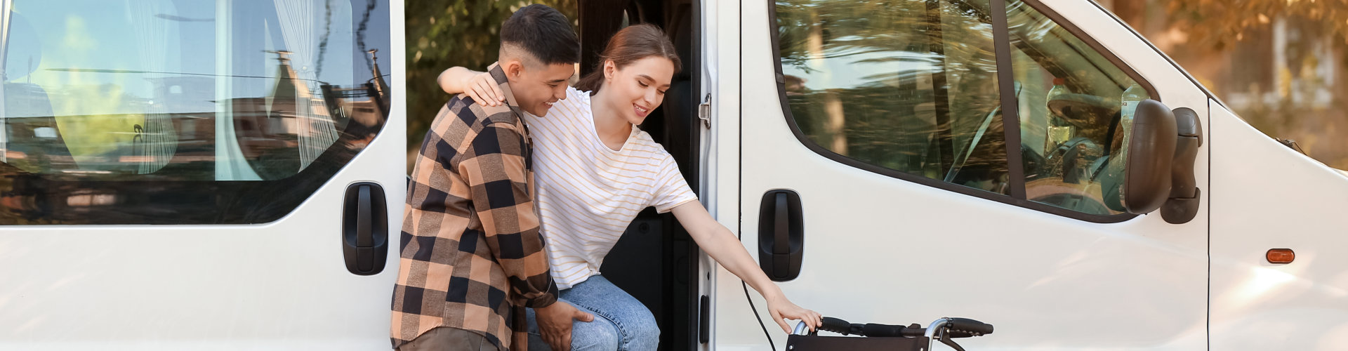 man helping woman getting out of the van