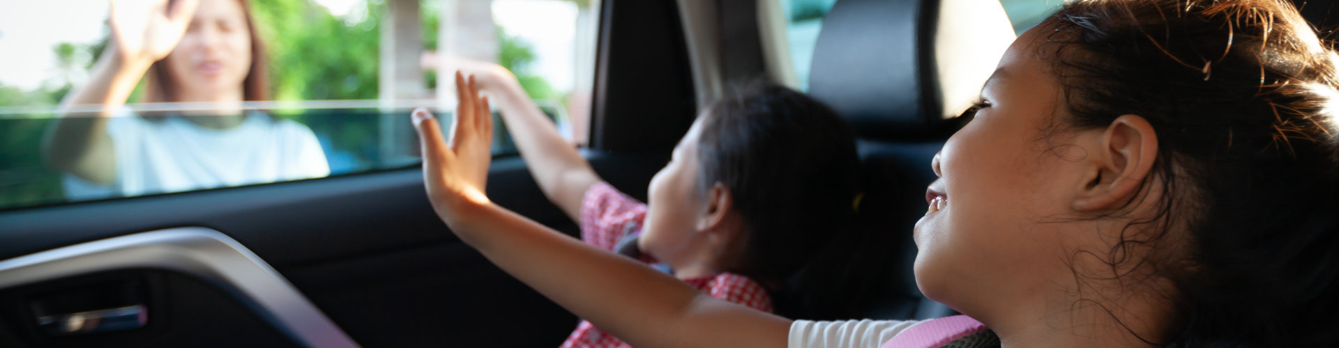 Back to school. Pupil girl with backpack and her sister sitting in the car and waving goodbye to her mother to get ready to school.